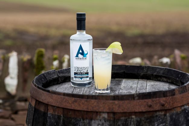 a bottle of haar vodka on a wooden barrel with a cocktail