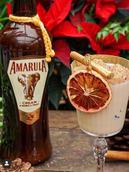 a cocktail next to a bottle of cream liqueur