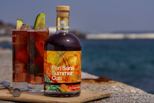 a bottle of pen sans summer cup with summer cocktails in a coastal setting