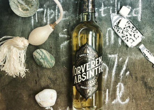 a bottle of moveren absinthe on a wooden table with chalk writing