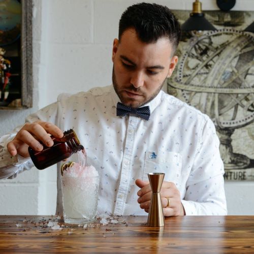 a man behind a bar making cocktails