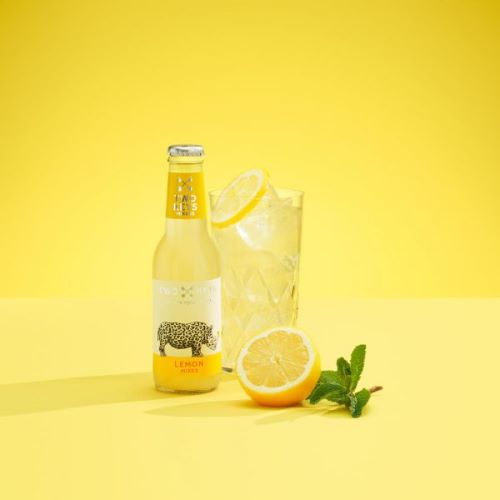 a bottle of two keys lemon mixer with a tom collins cocktail